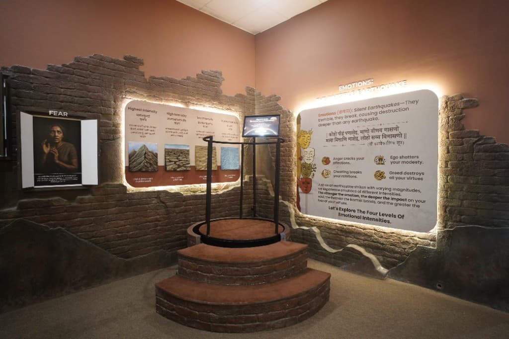 Emotions: The Silent Earthquake exhibit with brick-textured walls and interactive platform at Paras Dham Girnar