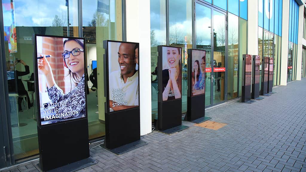 Printing and signage exhibitors demonstrating large format output and digital display technology on an exhibition stand