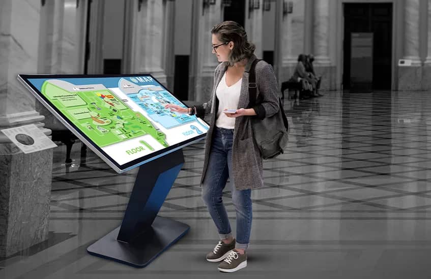 Export buyers exploring a pharmaceutical product portfolio on an interactive touchscreen at a healthcare trade exhibition stand